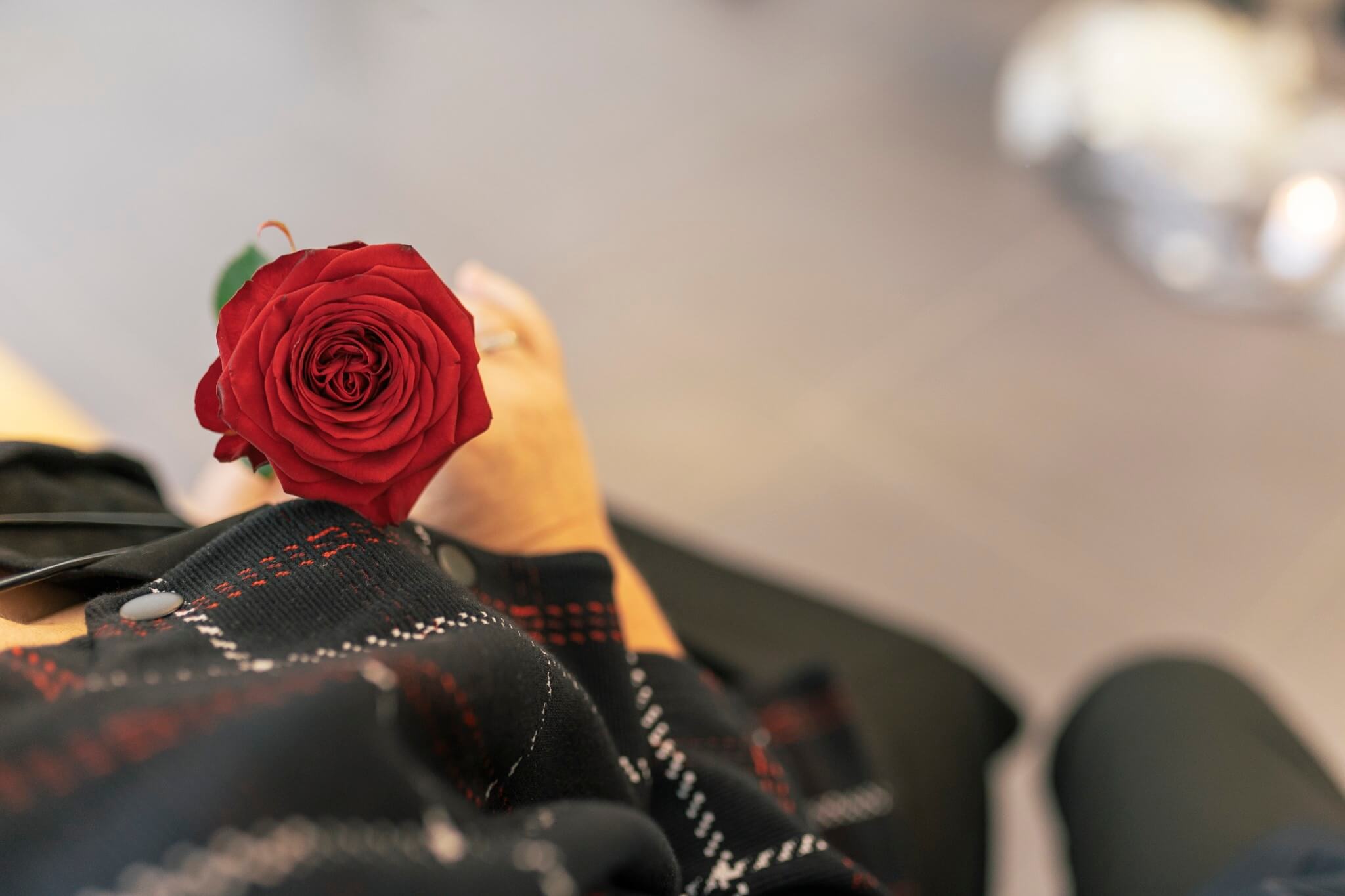 Frau hält rote Rose in ihrer Hand