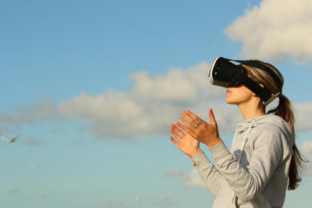 Virtual Reality - Eine Frau trägt draußen eine VR-Brille